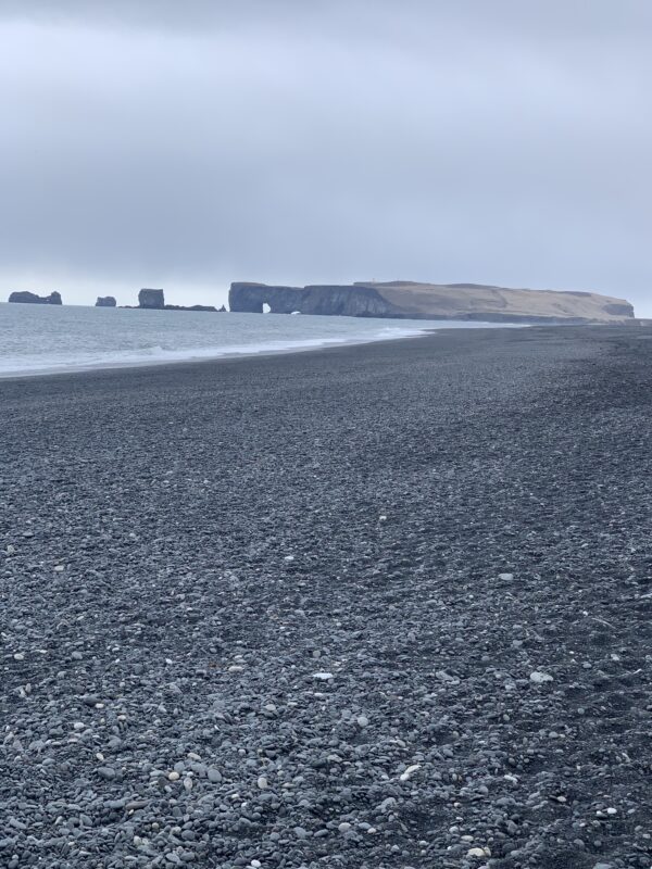On the South Coast of Iceland. Dyrholaey seen from the black sand