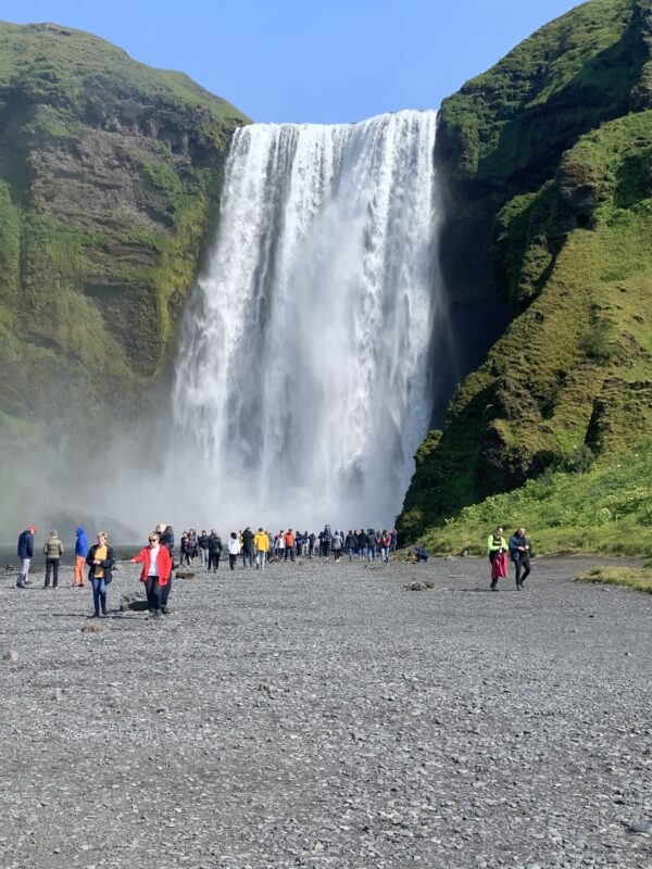 South Coast in Iceland. Tourist admiring the beauty of Skogafoss